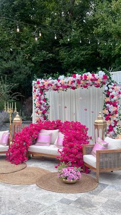 an outdoor seating area decorated with pink and white flowers