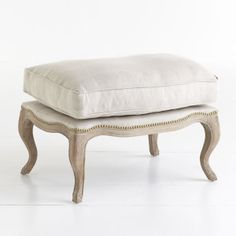 a white ottoman with a cushion on top