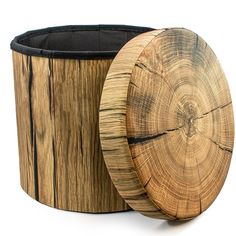 a wooden container with a black lining on the lid next to a tree stump basket