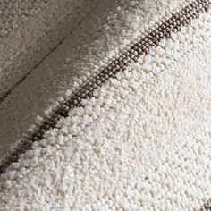 a close up view of a white and brown rug