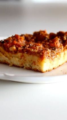 a piece of food on a plate sitting on a white table top with a blurry background