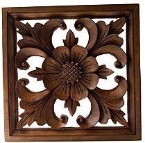 an intricately carved wooden panel with leaves and flowers on the center, is shown