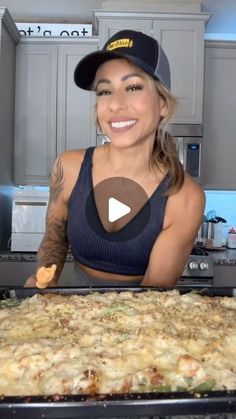 a woman in a black top is making pizza