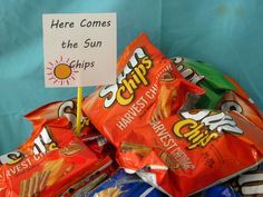 a pile of chips sitting next to a sign that says here comes the sun chips