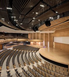 an empty auditorium with rows of seats and lights on the ceiling is pictured in this image