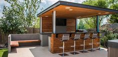 an outdoor bar with stools and a grill