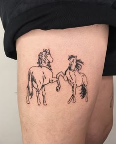 a woman's thigh with two horses drawn on the back of her leg, both facing each other