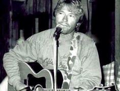 a man holding a guitar and singing into a microphone