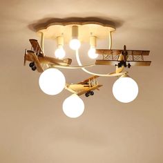 an airplane is suspended from the ceiling with four globes around it and three lights on each side