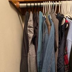 a rack with clothes hanging on it next to a wall