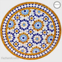 a decorative plate with blue, yellow and white designs on the surface is shown in this image