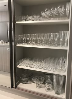 the shelves are filled with glasses and dishes