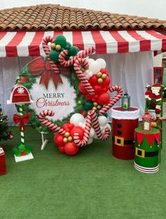 an outdoor christmas display with candy canes and decorations on the grass under a tent