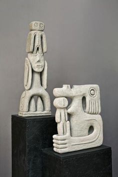 two sculptures sitting on top of black blocks