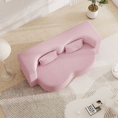 a pink couch sitting on top of a white rug