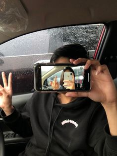 a woman taking a selfie in the back seat of a car with her cell phone