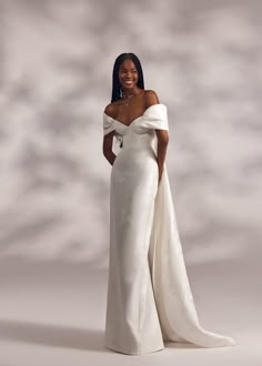 a woman in a white dress posing for the camera with her hands on her hips