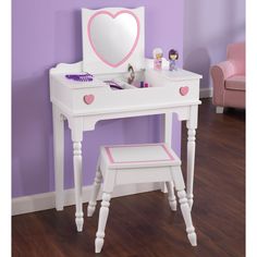 a white vanity table with a pink heart mirror and stool in front of purple wall