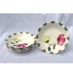 three plates with flower designs on them sitting next to each other