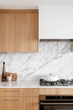 a kitchen with white marble counter tops and wooden cabinetry, along with an oven