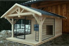 a dog house made out of wood with a cage on the roof and door open