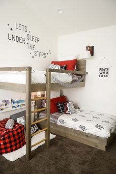 there are two bunk beds in this room with red pillows on the bottom and white walls