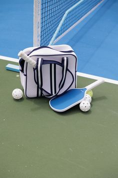 a tennis racket, ball and bag on the court