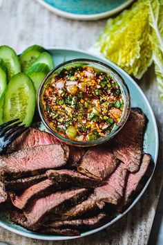 a plate with steak, pickles and salsa on it