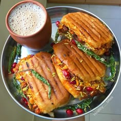 a plate with three sandwiches and a cup of coffee