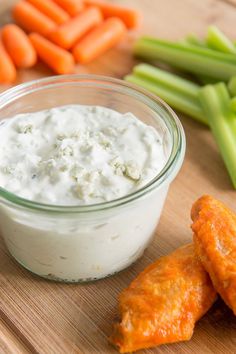 carrots, celery and dip are on a cutting board next to green beans