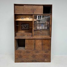 an old wooden cabinet with glass doors and drawers