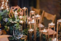 candles and greenery are arranged on the table for an elegant dinner or party setting