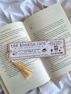 an open book with a tassel hanging from it's side on top of a bed