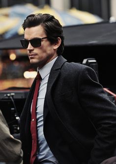 a man in a suit and tie walking down the street