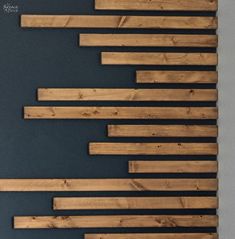 several pieces of wood are arranged on a black wall and one is made out of planks