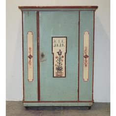 an old blue cabinet with flowers painted on it