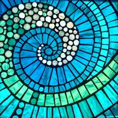 a close up view of a stained glass window with a spiral design in the center