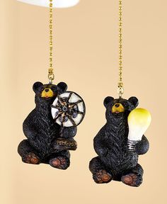 two black bear ornaments hanging from chains with light bulb and spinning wheel on it's back