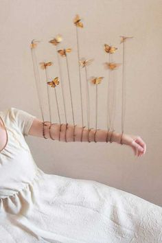 a woman laying on top of a bed with lots of sticks sticking out of her head