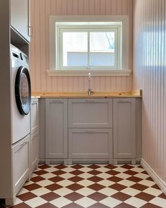 a washer and dryer in a small room with checkered flooring on the walls