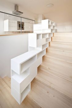 an empty room with white shelves and wooden floors