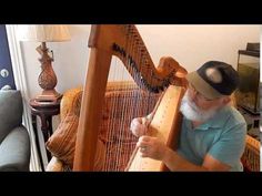 an old man is playing the harp in his living room