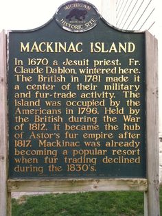 the marker for macknacc island is located in front of an old wooden fence