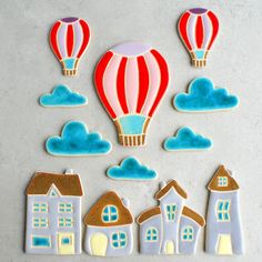 hot air balloons are flying over the houses and buildings on this tile wall art project