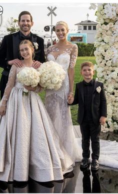 the bride and groom are posing with their two children