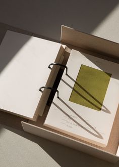 an open book sitting on top of a table next to a pair of scissors in a box