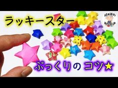 someone is holding some colorful stars in front of the camera with japanese writing on it