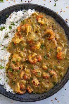 a bowl filled with shrimp and rice on top of a table