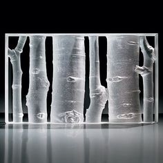 an artistic glass sculpture with trees in the middle and one tree on the other side