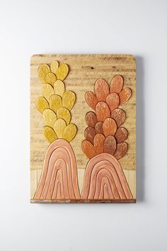 a wooden plaque with flowers and rainbows painted on the front in yellow, orange, and pink